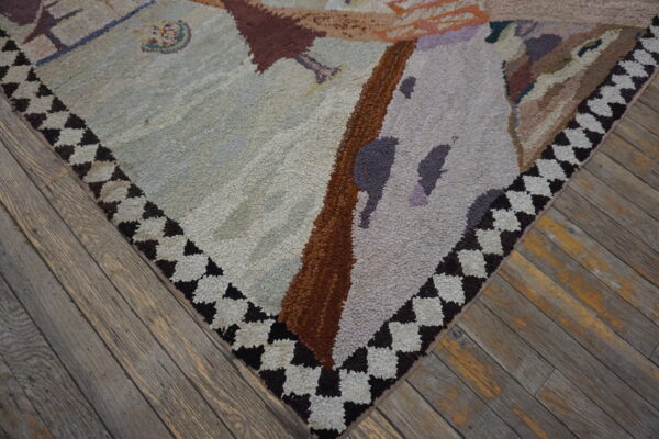 Textured light gray and brown abstract rug corner with a dark checkered border sits on distressed wood flooring.