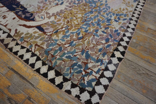Chunky pile rug with a colorful nature pattern and dark zigzag border rests on weathered wood planks.