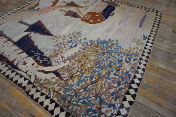 Cream high-pile rug with blue, gold, and brown abstract foliage and building designs on wood flooring.