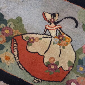 Textured rug with a scene of a woman in a red and cream dress among green foliage and multicolor flowers.