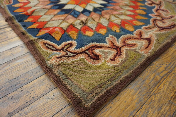 High-pile rug corner featuring a blue, orange, and tan medallion inside a moss green, scrolled border.