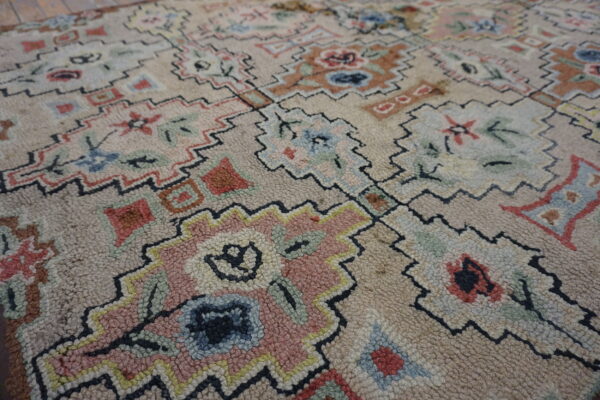 Textured, light beige rug featuring abstract floral and geometric designs outlined in black zigzags.