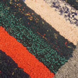 High-pile, chunky textured rug showing diagonal multicolored blocks of deep teal, orange, navy, and tan.