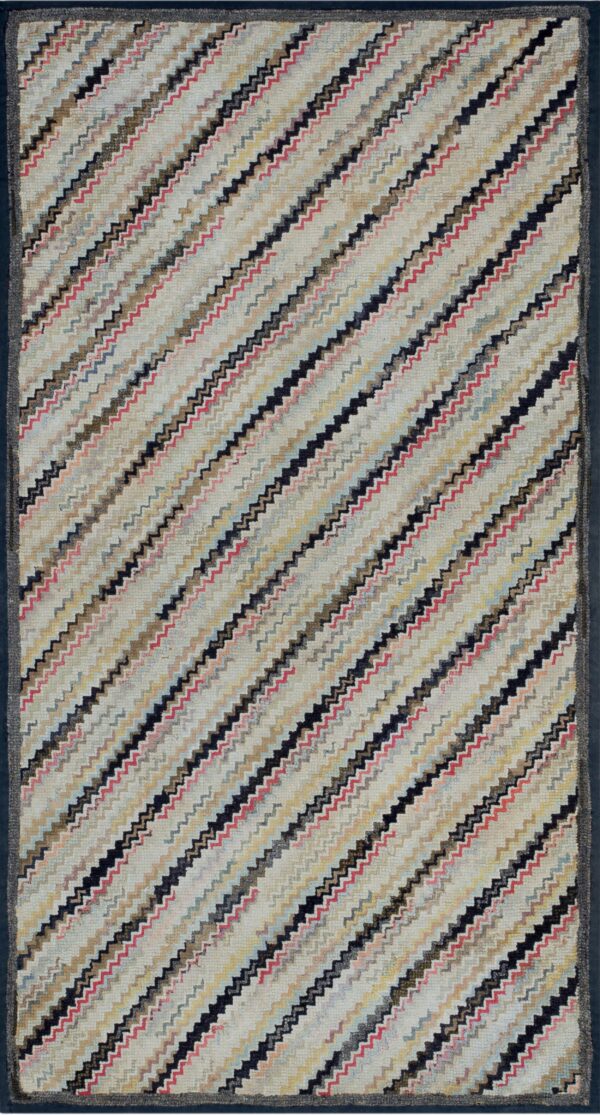 A runner rug with multi-colored diagonal zigzag stripes on a light background and a dark solid border.