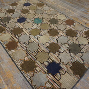 Earth-toned geometric rug featuring stars and multicolored striped crosses rests on weathered wood planks.
