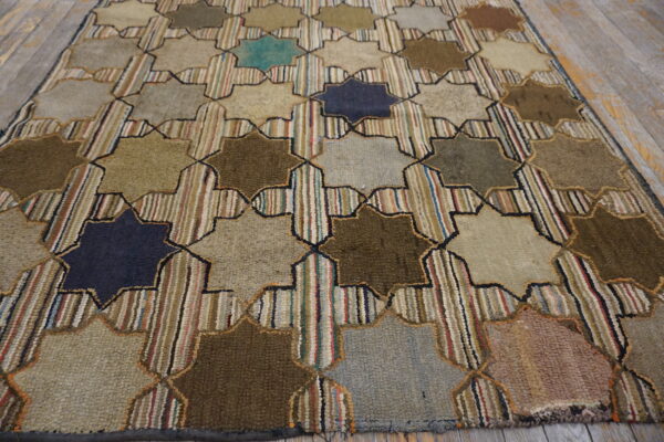 Geometric rug with alternating solid earth-tone stars and striped vertical bands on light wood flooring.