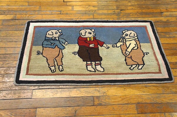 A low-pile rug showing three colorful dressed pigs on a blue background, placed on wood flooring.