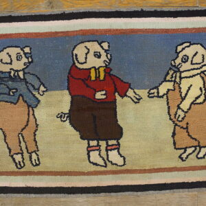 Textured rug depicting three costumed pigs on a blue and beige ground, bordered by multi-colored stripes.
