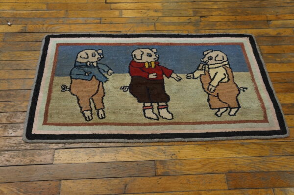 Colorful hooked rug featuring three clothed pigs in blue, red, and tan, resting on distressed wood planks.
