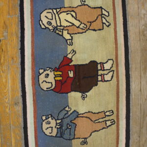 Hooked novelty rug features three cartoon animals in colorful clothing with a multicolored striped border on wood flooring.
