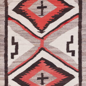 Vertical flatweave rug with stacked geometric diamond patterns in coral red, dark brown, and cream against gray.