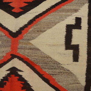 Geometric, low-pile rug featuring bold stepped patterns in cream, coral, dark brown, and heathered gray on a wood floor.