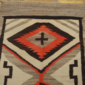 Geometric flatwoven rug in cream, gray, brown, and orange, featuring a serrated central diamond design.