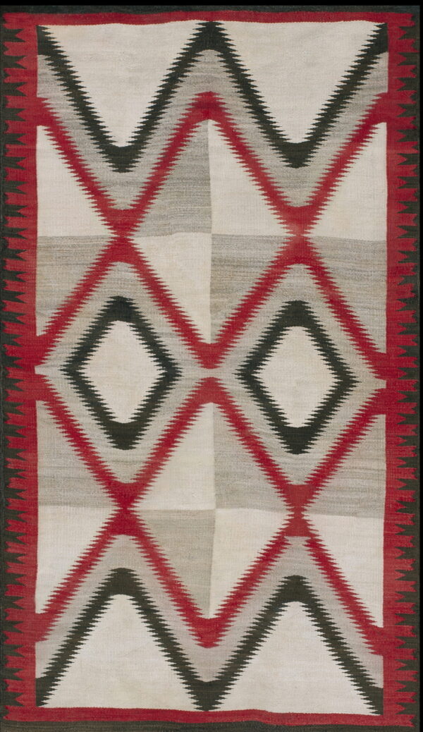 White, gray, red, and black flat-weave rug featuring large serrated diamond and zigzag designs.