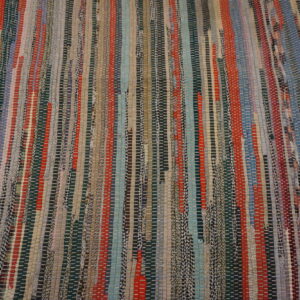 Flatwoven rug featuring vertical multicolored strips in red, blue, teal, gray, and earthy tones.
