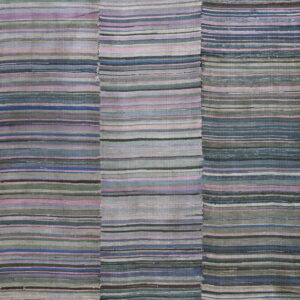 A patched flatweave rug with horizontal stripes of muted blue, gray, pink, and green colors.
