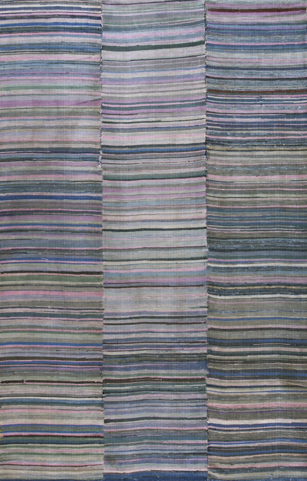 A patched flatweave rug with horizontal stripes of muted blue, gray, pink, and green colors.