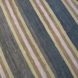 Diagonal striped rug in a coarse flat weave showing blue, gray, yellow, brown, and light beige colors.