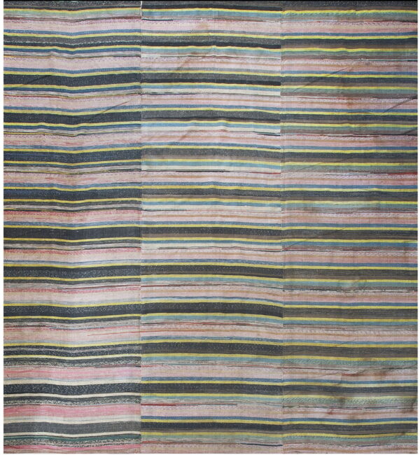 Low-pile rug with variegated horizontal stripes of pink, charcoal, yellow, and blue.