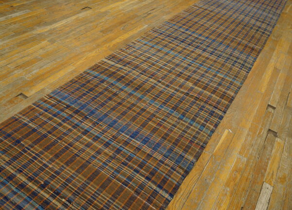 Vintage american rag rug hallway runner multicolor 1950s 10 Narrow flatweave american rag rug runner showing blue, orange, and brown plaid stripes on distressed wood flooring.