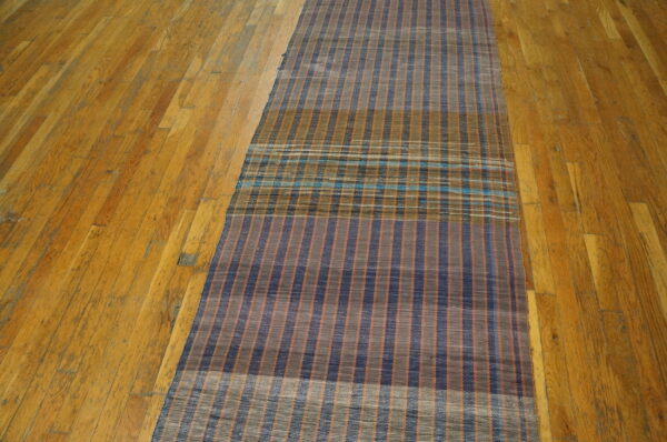 Vintage american rag rug hallway runner multicolor 1950s 2 Flatwoven american rag rug runner in navy, rust, and gray stripes with a turquoise plaid section on wood flooring.