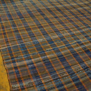Low-pile flatweave hallway runner featuring a checkered pattern in blue, brown, and bright orange on wood flooring.