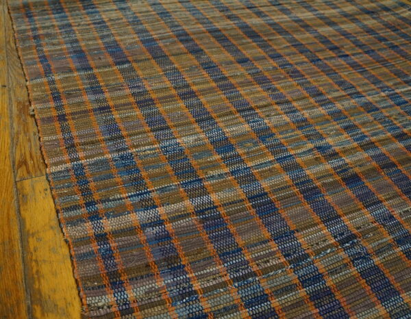 Vintage american rag rug hallway runner multicolor 1950s 5 Low-pile flatweave hallway runner featuring a checkered pattern in blue, brown, and bright orange on wood flooring.