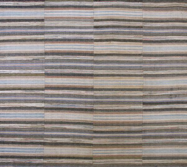 Flatweave rug with neutral, horizontal stripes of gray, taupe, blue, and brown across stitched vertical panels.