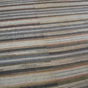 A low-profile rug with multi-colored horizontal stripes in shades of gray, blue, tan, and rust.