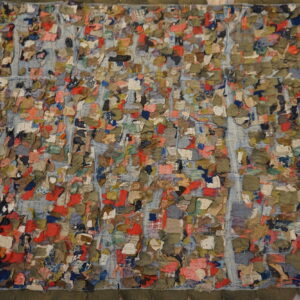 Multicolored, high-texture textile with red, green, and blue scraps stitched over a blue grid pattern.