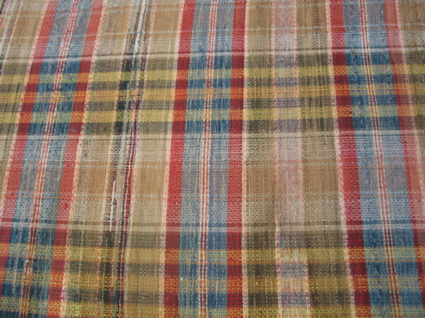 Flatwoven rug with a traditional plaid pattern using red, blue, tan, and olive colors.