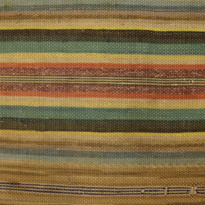 A flat-weave rag rug features horizontal stripes in multicolored shades of brown, teal, yellow, and rust next to wood planks.