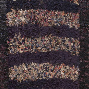 Textured close-up showing dark purple vertical stripes interspersed with multicolored, high-pile fabric pieces.