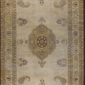 Low-pile beige rug with complex borders and a central floral medallion in gold, sage, and plum.