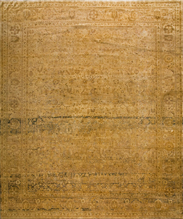 Monochromatic gold and dark brown traditional rug with a detailed border rests on distressed wood planks.