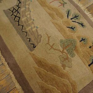 Sculpted tan and brown rug with a stylized landscape pattern and fringes, visible on rustic wood planks.