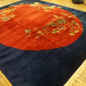 Navy rug featuring a prominent red circular medallion patterned with sprawling floral and vine designs.