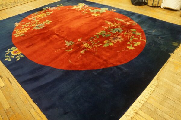Navy rug featuring a prominent red circular medallion patterned with sprawling floral and vine designs.
