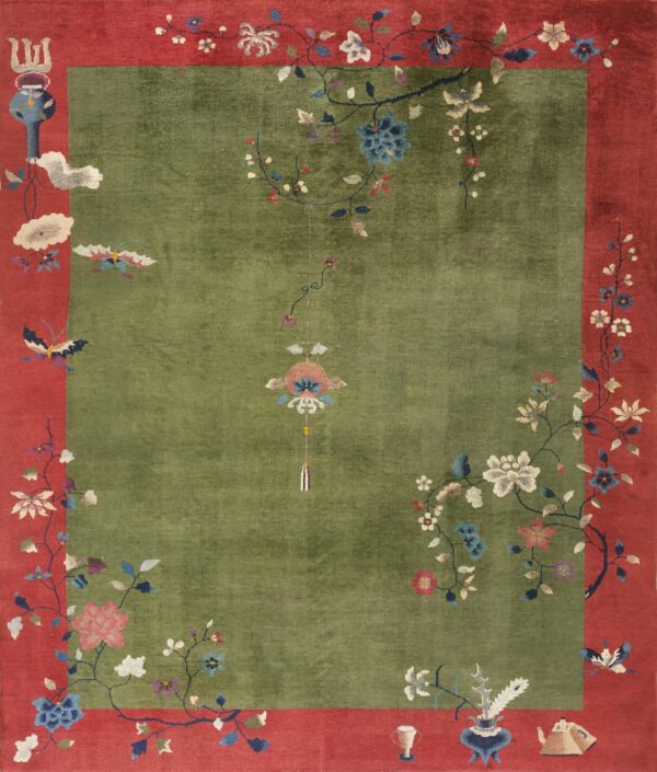 Olive green rug with a wide red border and colorful stylized floral and butterfly pattern.