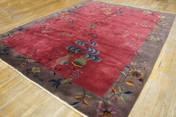Rose field rug featuring a taupe border and colorful floral patterns rests on distressed wood flooring.