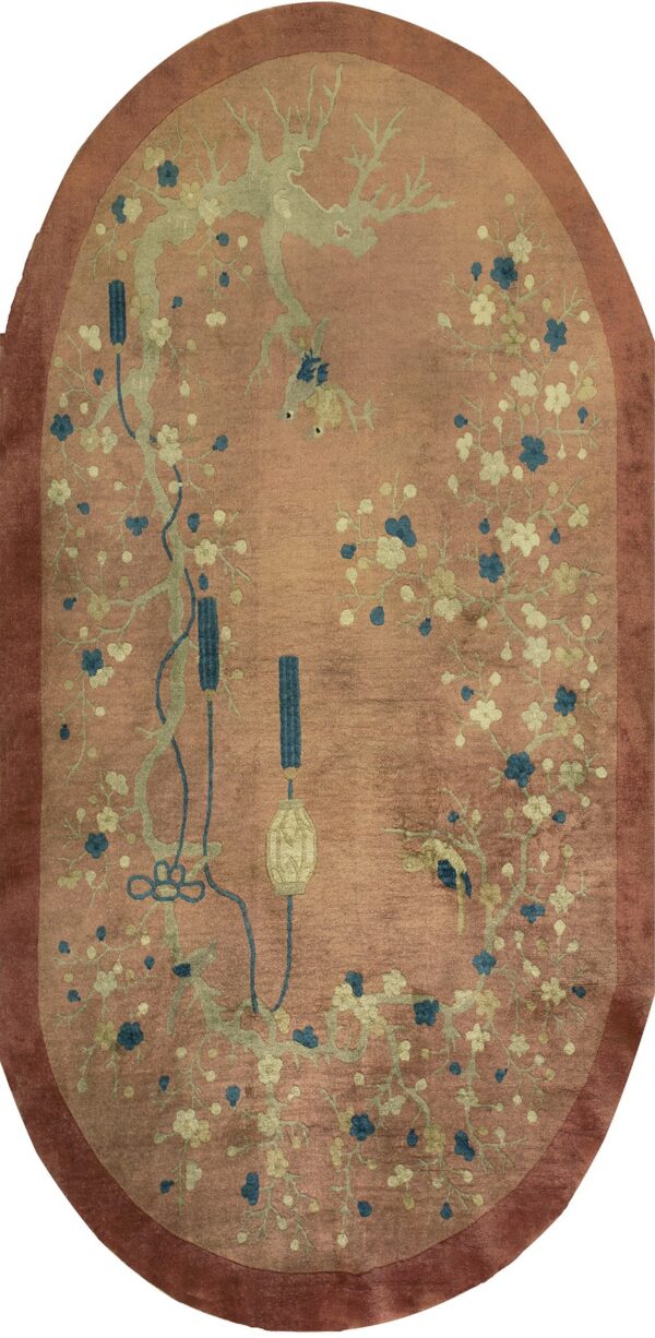 Oval rug featuring sage branches, blue and cream flowers, and birds on a dusty rose background.