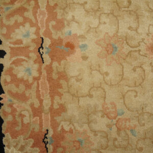 Matching floral rugs in pink and beige with black borders are laid on a distressed wood floor.