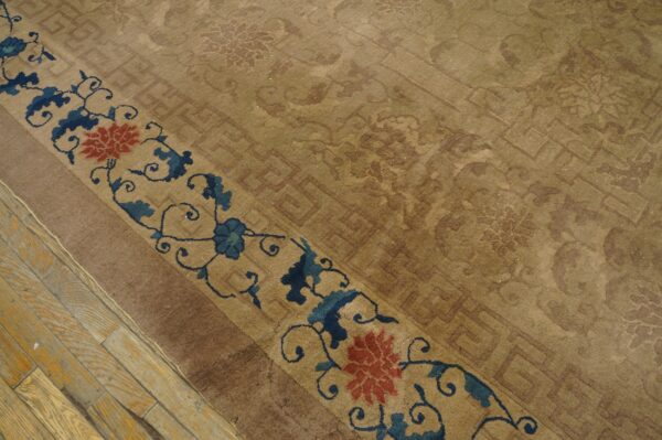 Tan rug with subtle tone-on-tone patterns and a blue and red floral border on distressed wood planks.