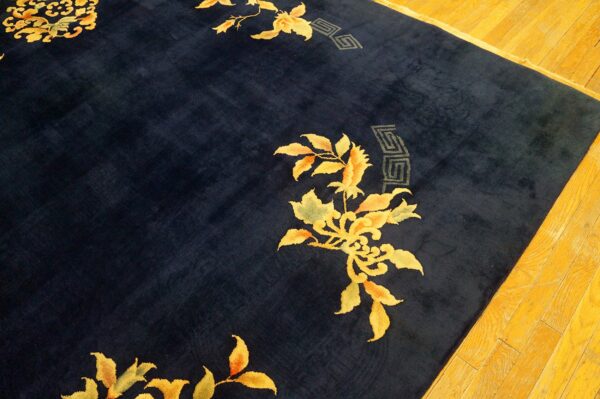Deep blue plush rug with bold golden yellow floral and gray geometric patterns rests on wood flooring.