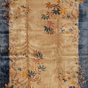 Rectangular rug with a shimmering tan field and a wide blue border covered in multicolored floral vines.