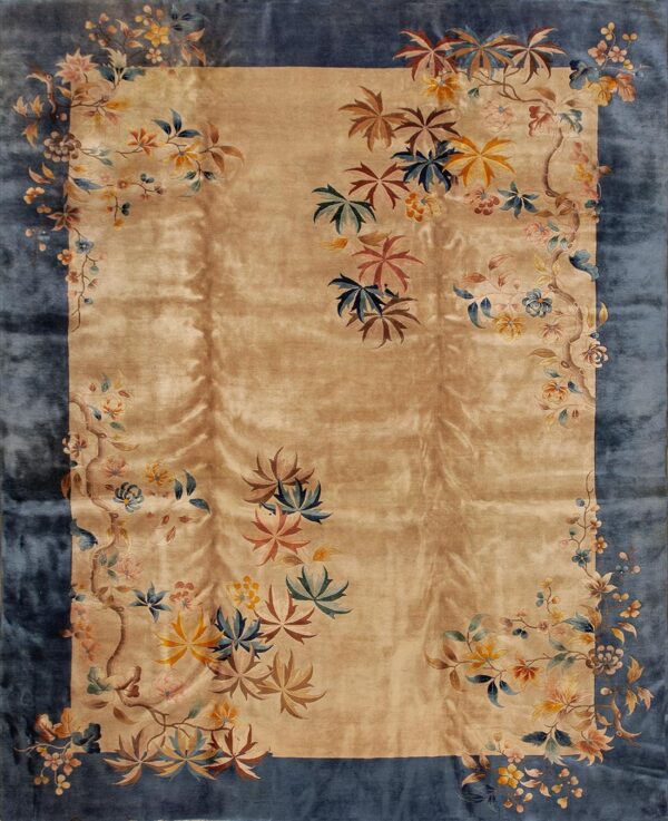 Rectangular rug with a shimmering tan field and a wide blue border covered in multicolored floral vines.