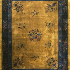 Luminous gold rug with a scattered blue and burgundy floral pattern framed by a wide navy border.