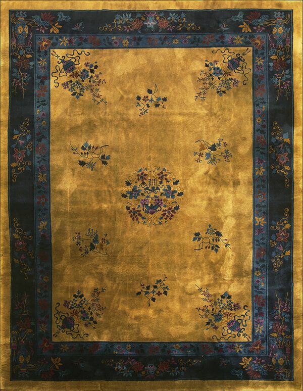 Luminous gold rug with a scattered blue and burgundy floral pattern framed by a wide navy border.