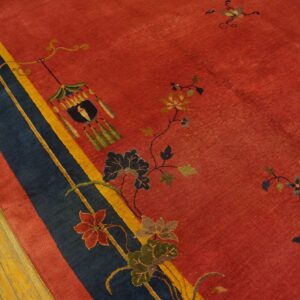 Red rug with blue, yellow, and red striped border, detailed floral vines, and a lantern motif on hardwood.