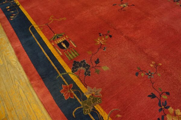 Red rug with blue, yellow, and red striped border, detailed floral vines, and a lantern motif on hardwood.